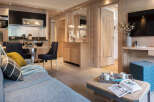 This stunning apartment boasts a spacious open-plan living area with a cozy sofa and modern kitchen.