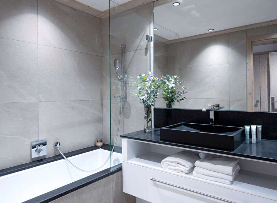 Modern bathroom with a sleek black sink and a spacious bathtub.