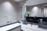 Modern bathroom with a sleek black sink and a spacious bathtub.