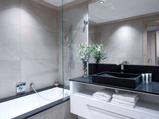 Modern bathroom with a sleek black sink and a spacious bathtub.