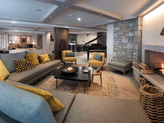 This luxurious living space boasts a spacious L-shaped sofa, perfect for relaxing by the cozy fireplace.