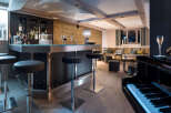This luxurious chalet boasts a stylish bar area complete with a sleek metal countertop, comfortable bar stools, and a sophisticated wine rack.