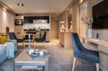 This stunning apartment boasts a spacious open-plan living area with a cozy sofa and a fully equipped kitchen.