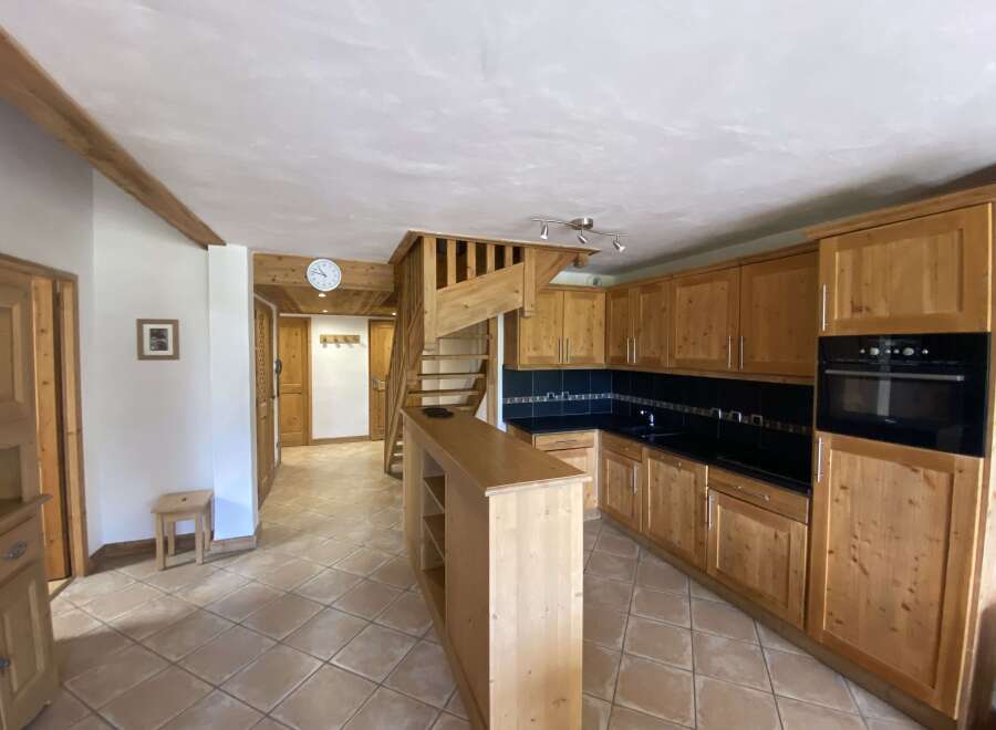 This charming apartment boasts a fully equipped kitchen with wooden cabinetry, a convenient breakfast bar, and modern appliances.