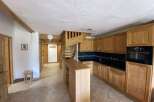 This charming apartment boasts a fully equipped kitchen with wooden cabinetry, a convenient breakfast bar, and modern appliances.