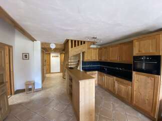 This charming apartment boasts a fully equipped kitchen with wooden cabinetry, a convenient breakfast bar, and modern appliances.