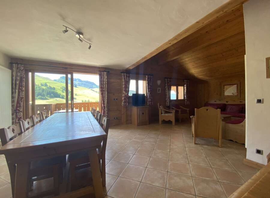 This stunning chalet boasts a spacious open-plan living area with a large dining table perfect for family gatherings, and comfortable seating arrangements for relaxation.
