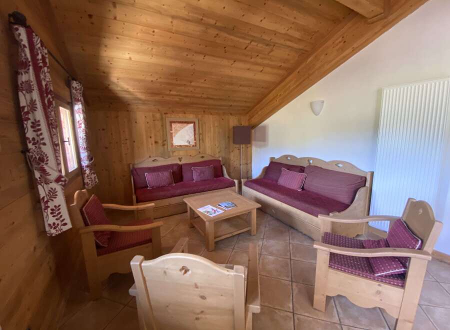 Cozy chalet living room with wooden furniture and tiled floor.