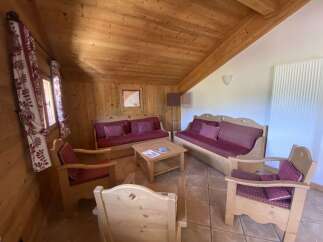 Cozy chalet living room with wooden furniture and tiled floor.