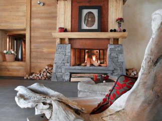 This stunning chalet boasts a rustic-chic living room with a large stone fireplace as the focal point.