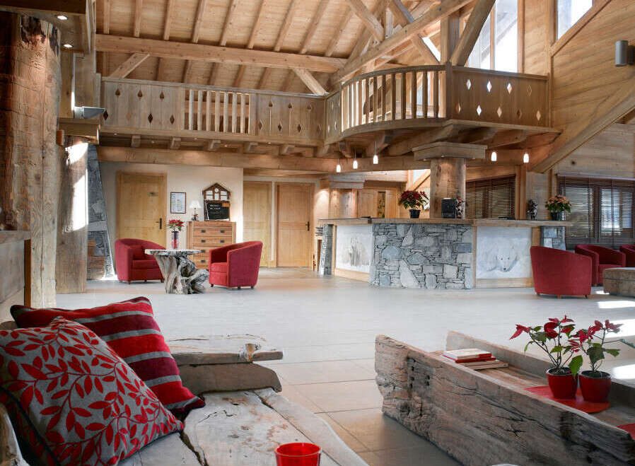 This stunning hotel lobby boasts a rustic-chic design with exposed wooden beams, a stone fireplace, and comfortable seating areas.