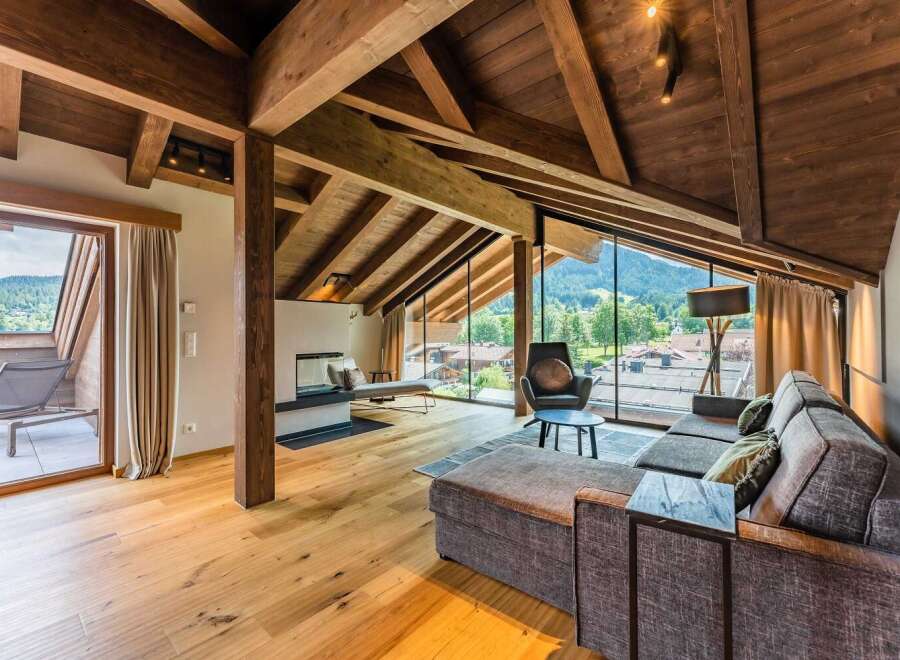 This luxurious chalet boasts a stunning open-plan living area with floor-to-ceiling windows offering breathtaking mountain views.