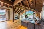 This luxurious chalet boasts a stunning open-plan living area with floor-to-ceiling windows offering breathtaking mountain views.