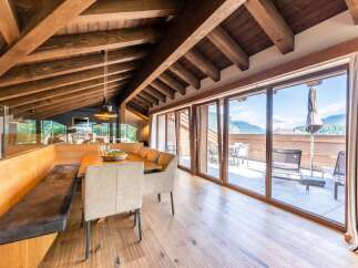 This luxurious penthouse boasts a stunning mountain view from its expansive terrace, accessible through large sliding glass doors.