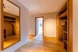 This stunning hallway boasts built-in wooden wardrobes on either side, providing ample storage space.