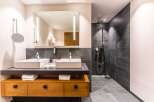 This luxurious bathroom boasts a double vanity with sleek, modern sinks and ample storage.