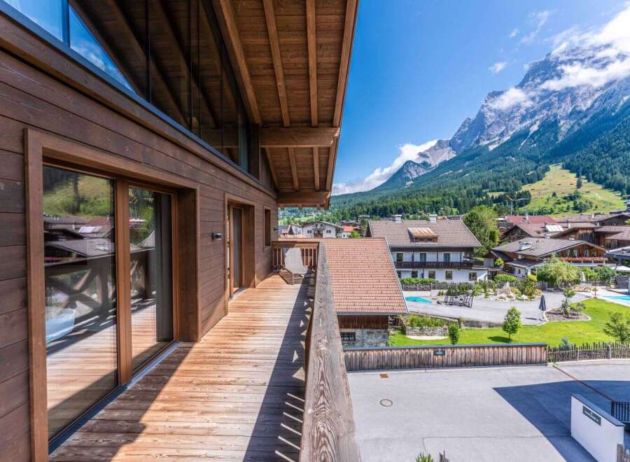 This stunning mountain chalet boasts a spacious balcony with breathtaking views, perfect for enjoying the fresh alpine air.