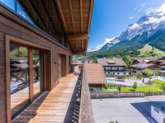 This stunning mountain chalet boasts a spacious balcony with breathtaking views, perfect for enjoying the fresh alpine air.