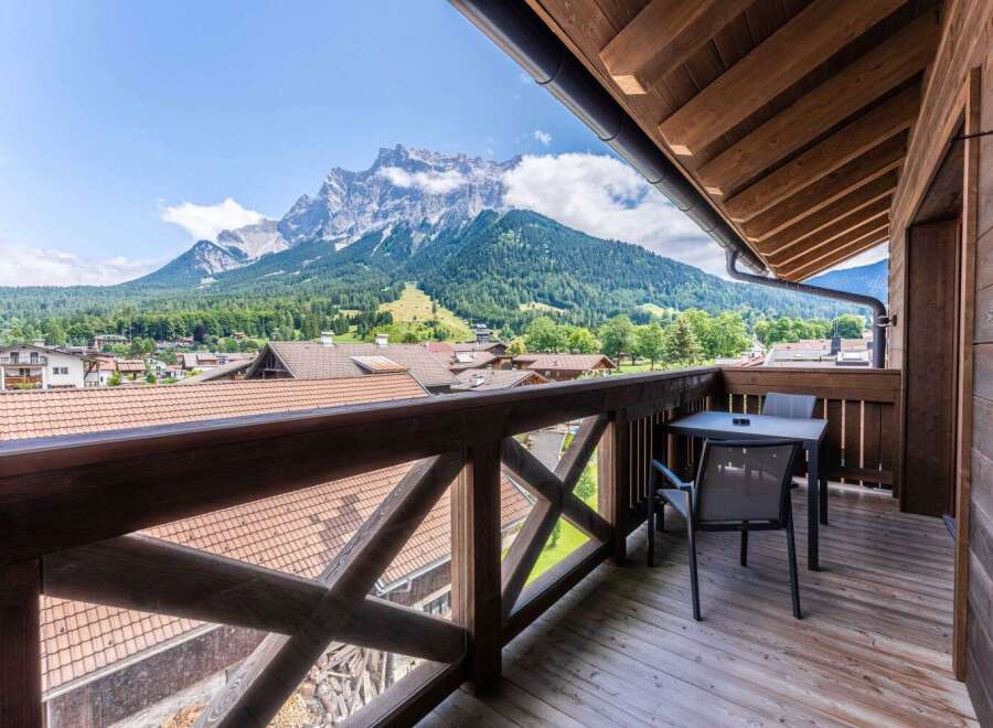 This stunning balcony boasts breathtaking mountain views and a private seating area, perfect for relaxing and enjoying the scenery.