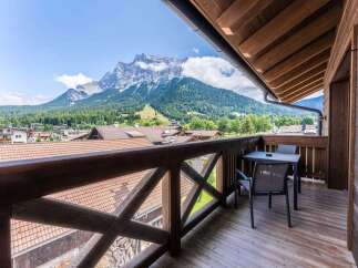 This stunning balcony boasts breathtaking mountain views and a private seating area, perfect for relaxing and enjoying the scenery.