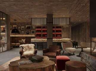 This luxurious lodge boasts a stunning lobby with a rustic-chic design, featuring a large stone fireplace, comfortable leather armchairs, and a unique wooden coffee table.
