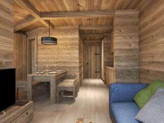 This stunning chalet boasts a spacious open-plan living area with a rustic wooden dining table and comfortable blue sofa.