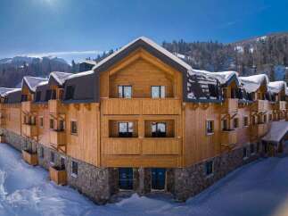 Nestled in a snow-covered mountainside, this stunning wooden chalet offers breathtaking views and luxurious accommodations.