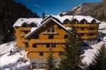 Nestled in a snowy mountainside, this stunning wooden chalet offers breathtaking views and luxurious accommodations.