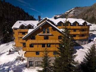 Nestled in a snowy mountainside, this stunning wooden chalet offers breathtaking views and luxurious accommodations.