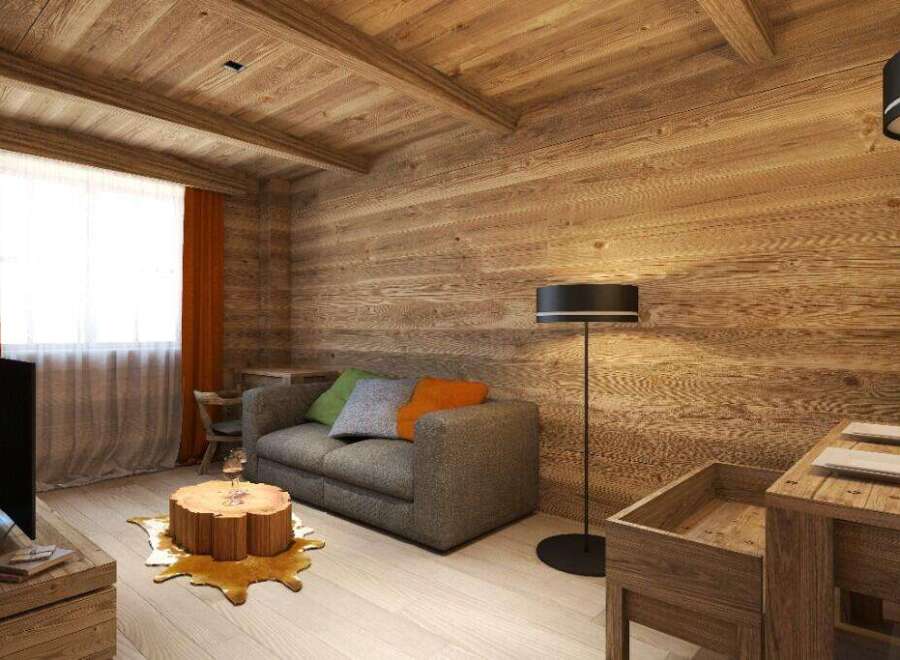 Cozy wooden cabin living room with a grey sofa, tree stump coffee table, and floor lamp.