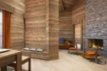 This stunning chalet boasts a cozy living area with a wood-burning fireplace, creating a warm and inviting atmosphere.