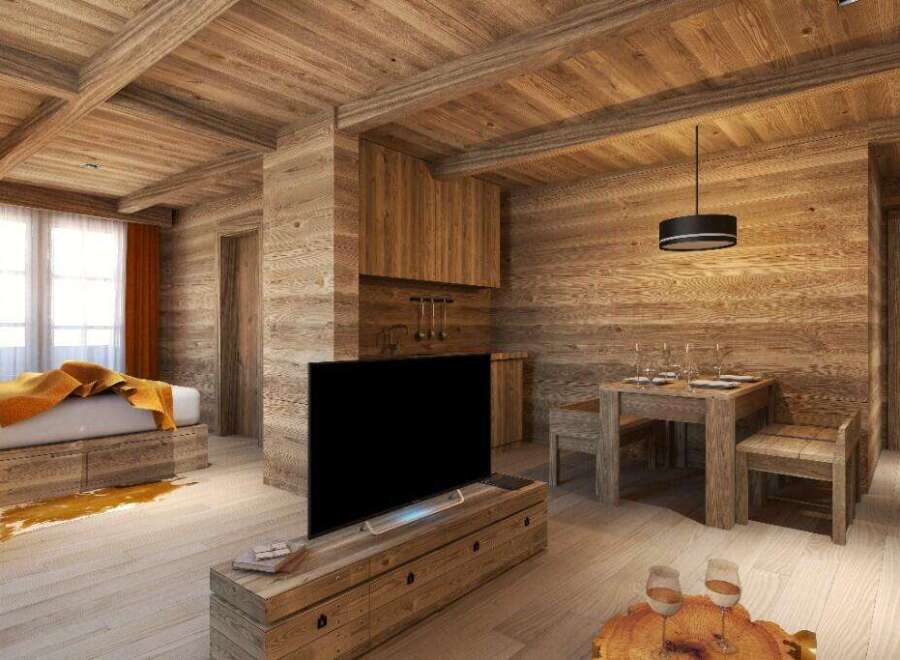 This stunning chalet boasts a cozy living space with exposed wooden beams, a flat-screen TV, and a rustic dining area.