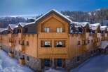 Nestled in a snow-covered mountainside, this stunning wooden chalet offers breathtaking views and luxurious accommodations.