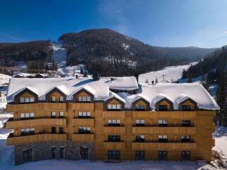 This stunning wooden chalet boasts breathtaking mountain views and offers luxurious accommodations perfect for a ski getaway.