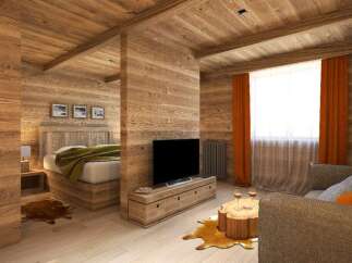 This stunning chalet-style room boasts a cozy living area with a rustic wooden coffee table and comfortable sofa, complemented by warm orange curtains and a large window.