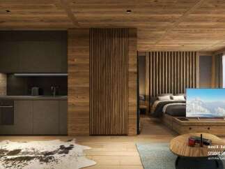 This stunning hotel room boasts a modern kitchen with dark gray cabinetry and wooden accents, seamlessly integrated into a cozy living space.