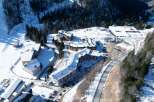 Nestled in a snow-covered mountainside, this stunning property boasts multiple buildings with unique architectural designs.