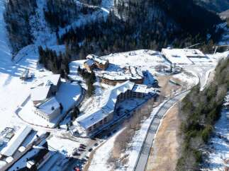 Nestled in a snow-covered mountainside, this stunning property boasts multiple buildings with unique architectural designs.