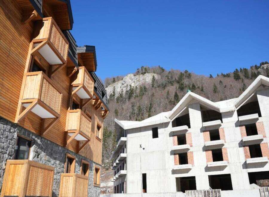 Discover this stunning property nestled in the mountains, featuring two buildings with unique architectural styles.