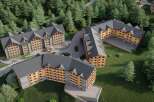 Nestled in a lush forest, this stunning hotel complex boasts multiple buildings with charming wooden accents and spacious balconies.