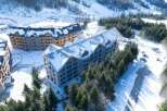 Luxury ski resort nestled in a snowy mountainside, featuring stunning aerial views of modern architectural design.