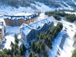 Luxury ski resort nestled in a snowy mountainside, featuring stunning aerial views of modern architectural design.