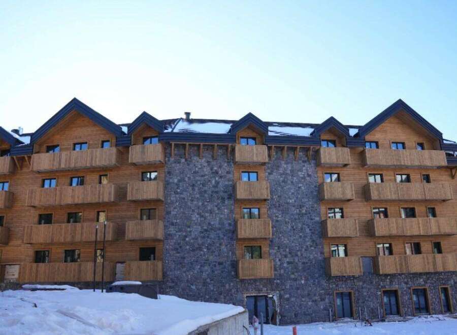 This stunning chalet-style hotel boasts a unique blend of wood and stone, creating a warm and inviting atmosphere.