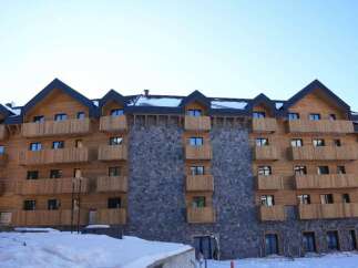 This stunning chalet-style hotel boasts a unique blend of wood and stone, creating a warm and inviting atmosphere.