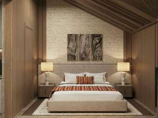 This stunning bedroom boasts a cozy and sophisticated atmosphere, featuring a plush bed with a textured headboard and warm-toned bedding.