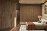 This luxurious bedroom boasts a stunning wood-paneled wall, complemented by a plush bed with a textured throw.
