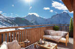 Luxury chalet apartment balcony with breathtaking mountain views.