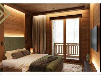 This stunning bedroom boasts a cozy and luxurious design, featuring a plush bed with a green quilted throw, complemented by wooden walls and floors.