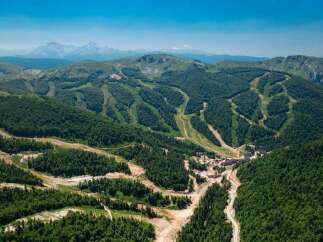 Nestled in a lush mountain range, this stunning property boasts breathtaking views and ski slopes.