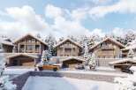 Luxury chalet-style homes nestled in a snowy mountain setting, offering stunning views and ample parking.